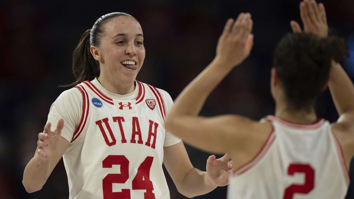 Utah guard Kennady McQueen, left, celebrates with guard Inês Vieira during a timeout in the first half of an NCAA basketball game against South Dakota State on Saturday, March 23, 2024, in Spokane, Wash.