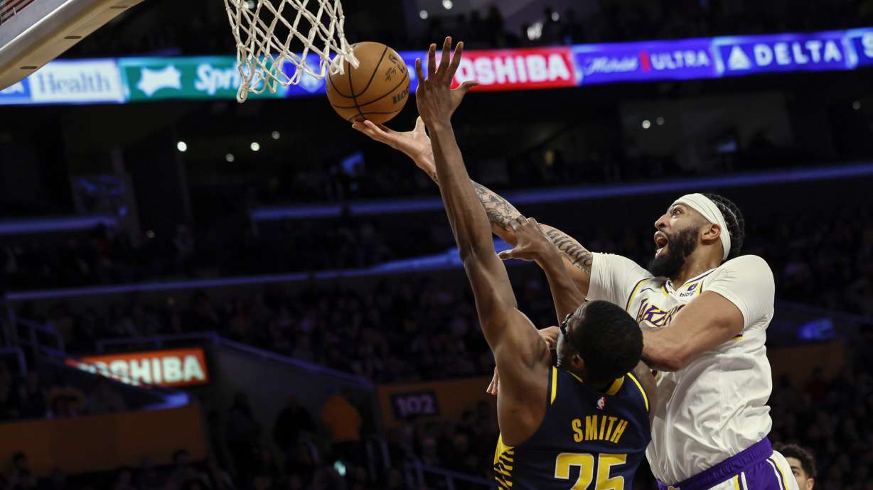 Los Angeles Lakers forward-center Anthony Davis, right, scores over Indiana Pacers forward-center Jalen Smith (25) during the first half of an NBA basketball game, Sunday, March 24, 2024, in Los Angeles.