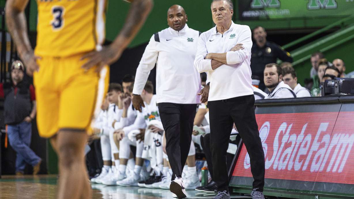 FILE - Marshall coach Dan D'Antoni, right, and assistant coach Cornelius Jackson talk on the sideline during the team's NCAA college basketball game against Coppin State, Nov. 19, 2022, in Huntington, W.Va. Jackson was named Monday, March 25, 2024, to replace D’Antoni as Marshall's head coach.