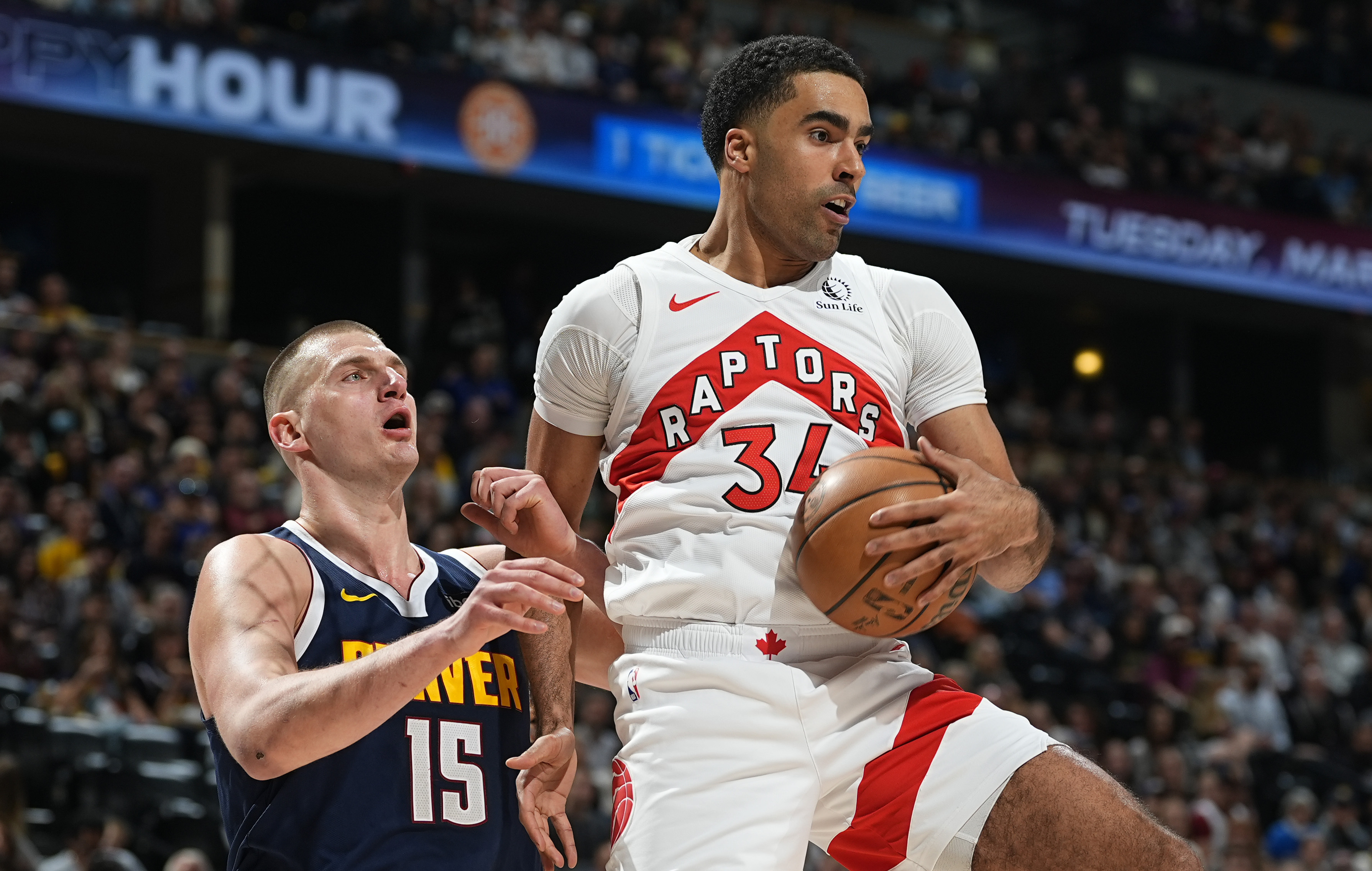 Toronto Raptors center Jontay Porter, right, pulls in a rebound as Denver Nuggets center Nikola Jokic, left, defends in the first half of an NBA basketball game Monday, March 11, 2024, in Denver.