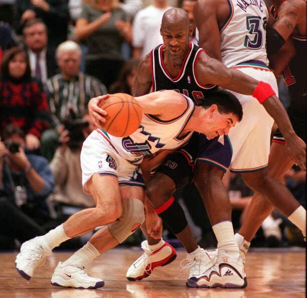 John Stockton drives around Michael Jordan as Karl Malone sets the pick down court during a game at the Delta Center, Feb. 4, 1998.