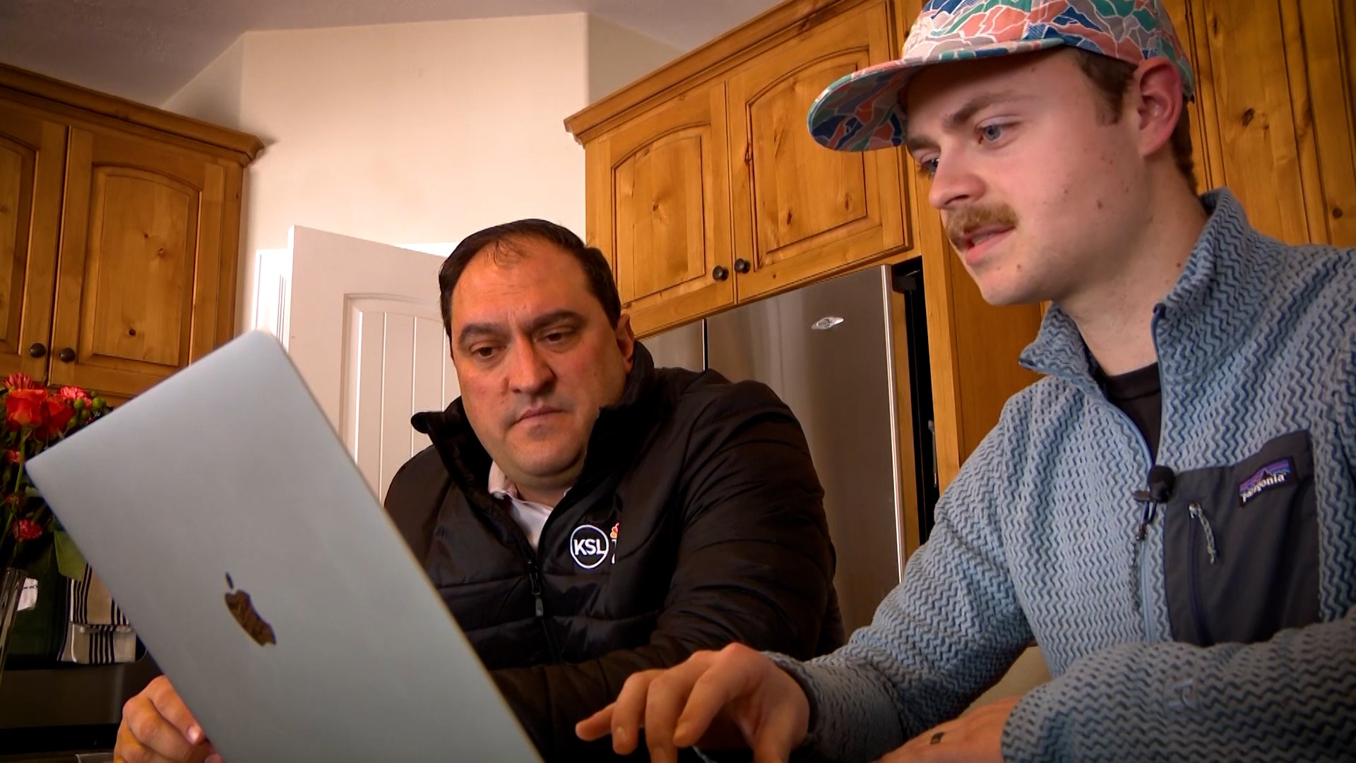 Sam Kochevar shows KSL’s Matt Gephardt several counterfeit obituaries of his younger brother, Josh, that he found online.