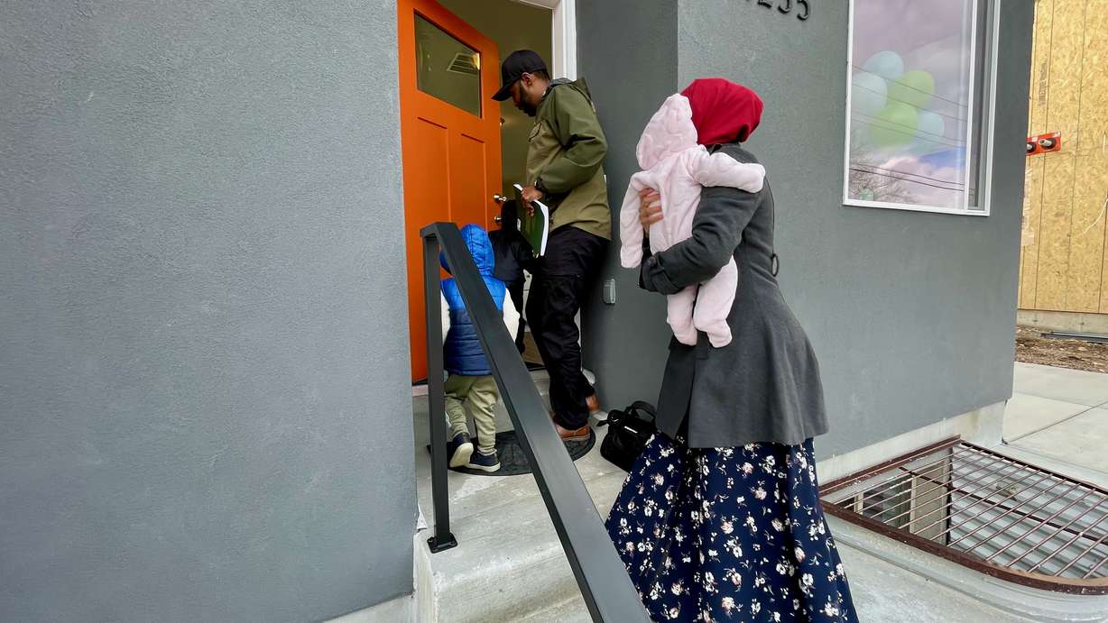 Hassan Sheikh, at the door, enters his new Salt Lake Valley Habitat for Humanity home in Kearns with his family on Tuesday It's located in the Field of Dreams community, which is nearly complete.