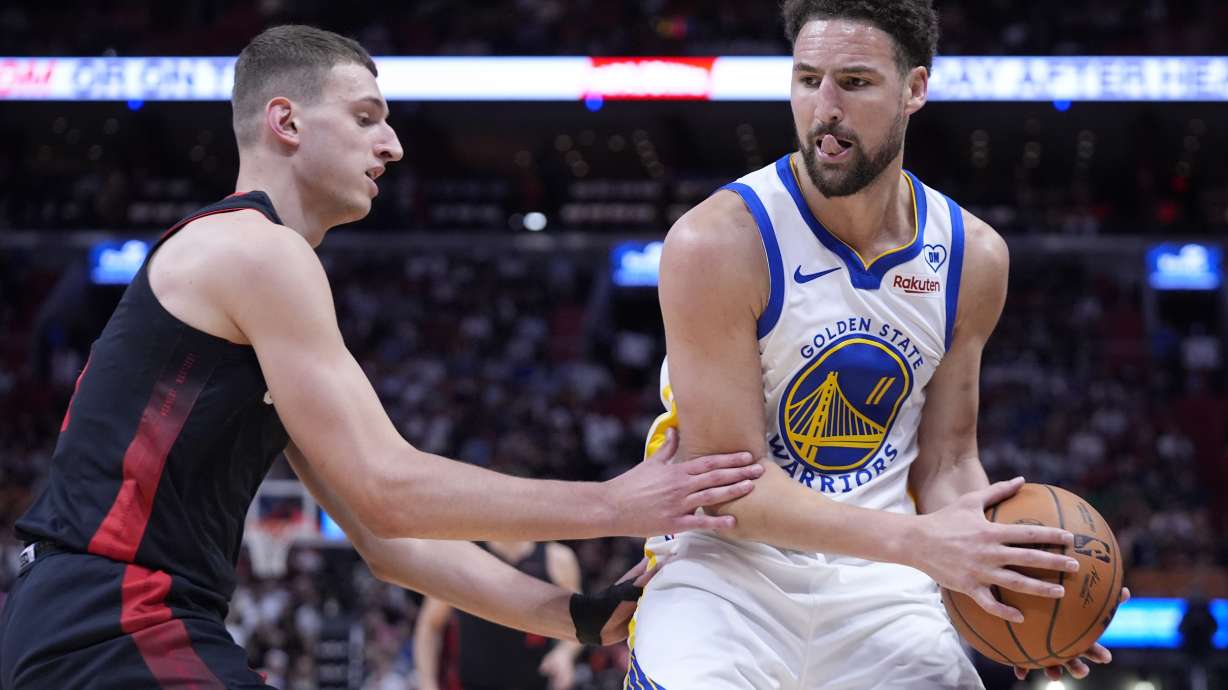 Golden State Warriors guard Klay Thompson (11) looks for an opening past Miami Heat forward Nikola Jovic (5) during the first half of an NBA basketball game, Tuesday, March 26, 2024, in Miami.