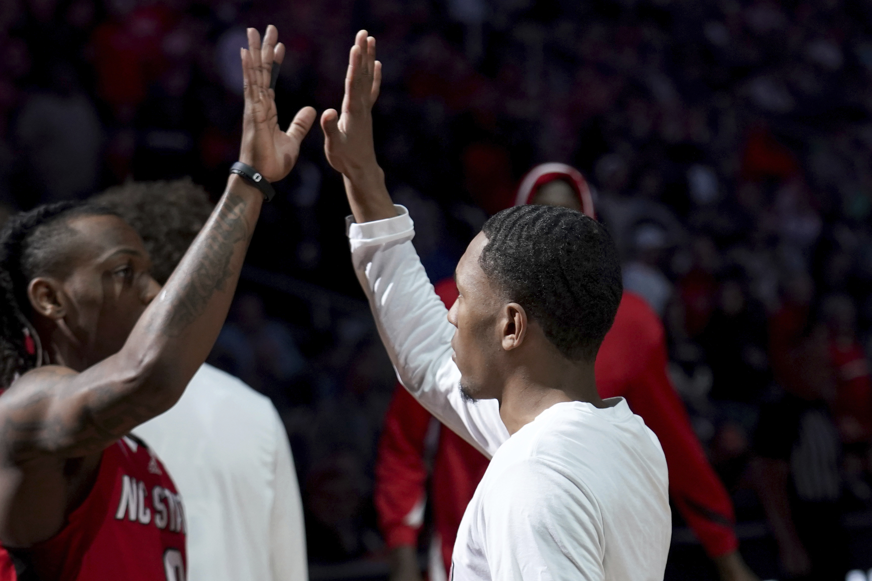 FILE - North Carolina State's KJ Keatts, right, orchestrates the pregame handshake with DJ Horne before a college basketball game against Texas Tech in the first round of the men's NCAA Tournament on March 21, 2024, in Pittsburgh. The pregame handshake has become a staple of college basketball during March Madness. 