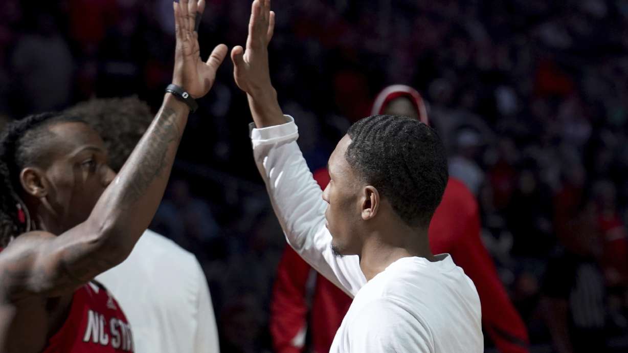 FILE - North Carolina State's KJ Keatts, right, orchestrates the pregame handshake with DJ Horne before a college basketball game against Texas Tech in the first round of the men's NCAA Tournament on March 21, 2024, in Pittsburgh. The pregame handshake has become a staple of college basketball during March Madness.