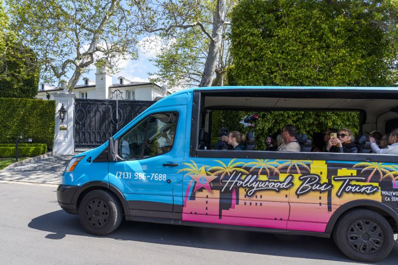 A Hollywood Bus Tours van carrying tourists stops momentarily by the front gate of a property belonging to Sean "Diddy" Combs, Tuesday in Los Angeles, the day after federal Homeland Security Investigations agents and other law enforcement executed a raid as part of an ongoing sex trafficking investigation by federal authorities in New York.