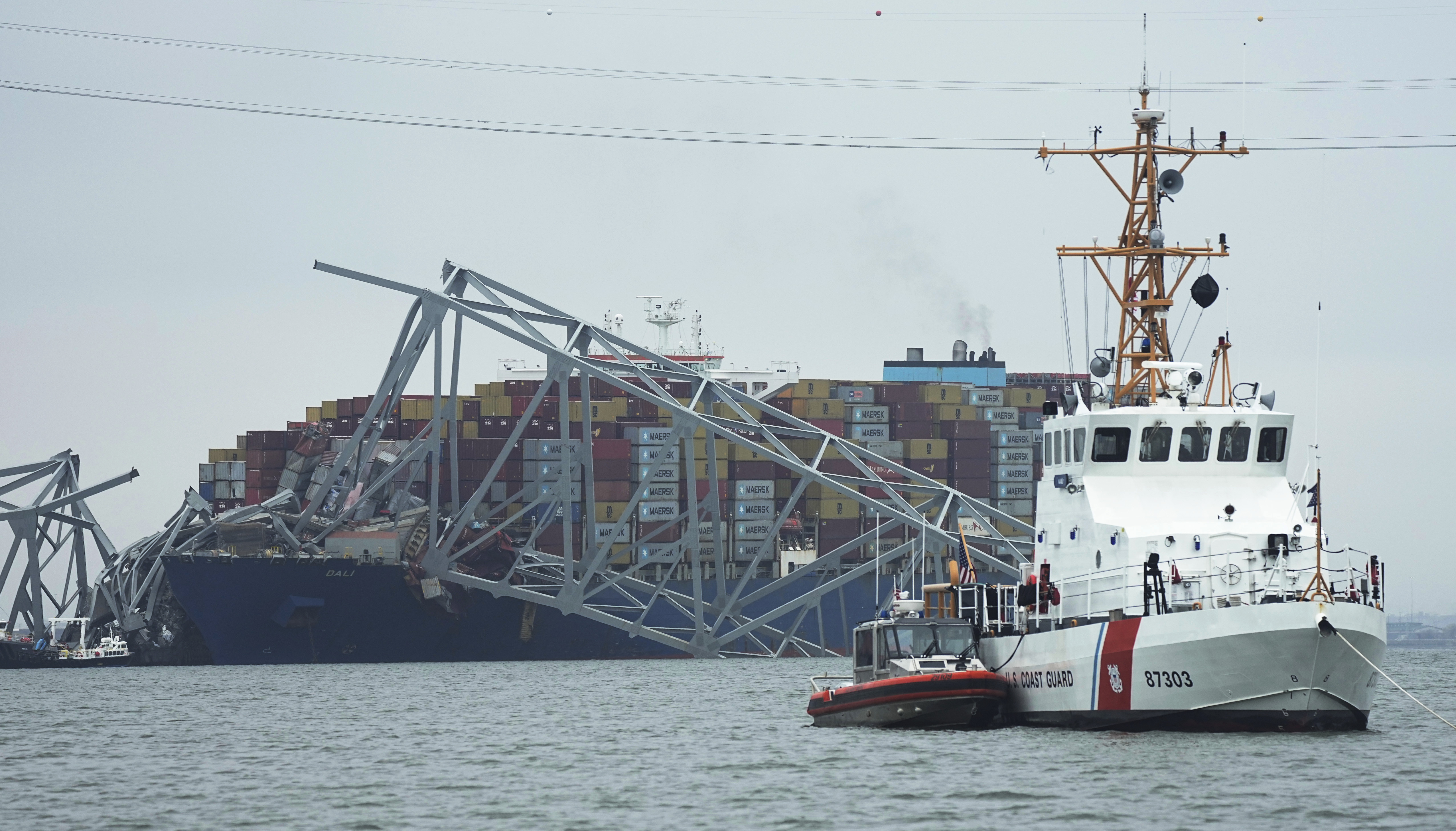 A Coast Guard cutter patrols in front of a cargo ship stuck under the part of the Francis Scott Key Bridge after the ship hit the bridge, Wednesday in Baltimore, Md.