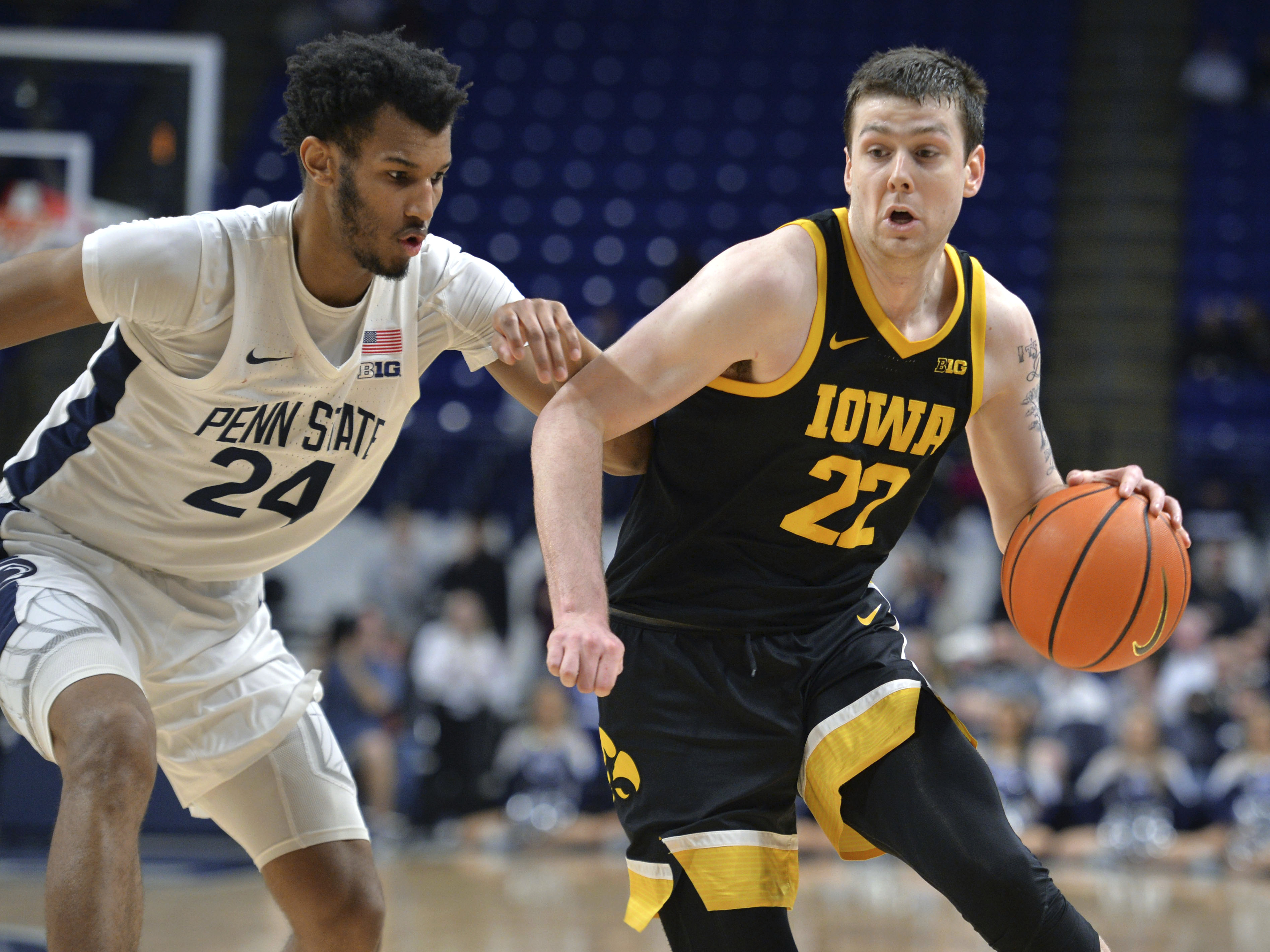 FILE - Iowa's Patrick McCaffery (22) drives on Penn State's Zach Hicks (24) during the second half of an NCAA college basketball game Thursday, Feb. 8, 2024, in State College, Pa. Iowa's Patrick McCaffery, son of Hawkeyes coach Fran McCaffery, has entered the transfer portal, the school confirmed Wednesday, March 27, 2024.