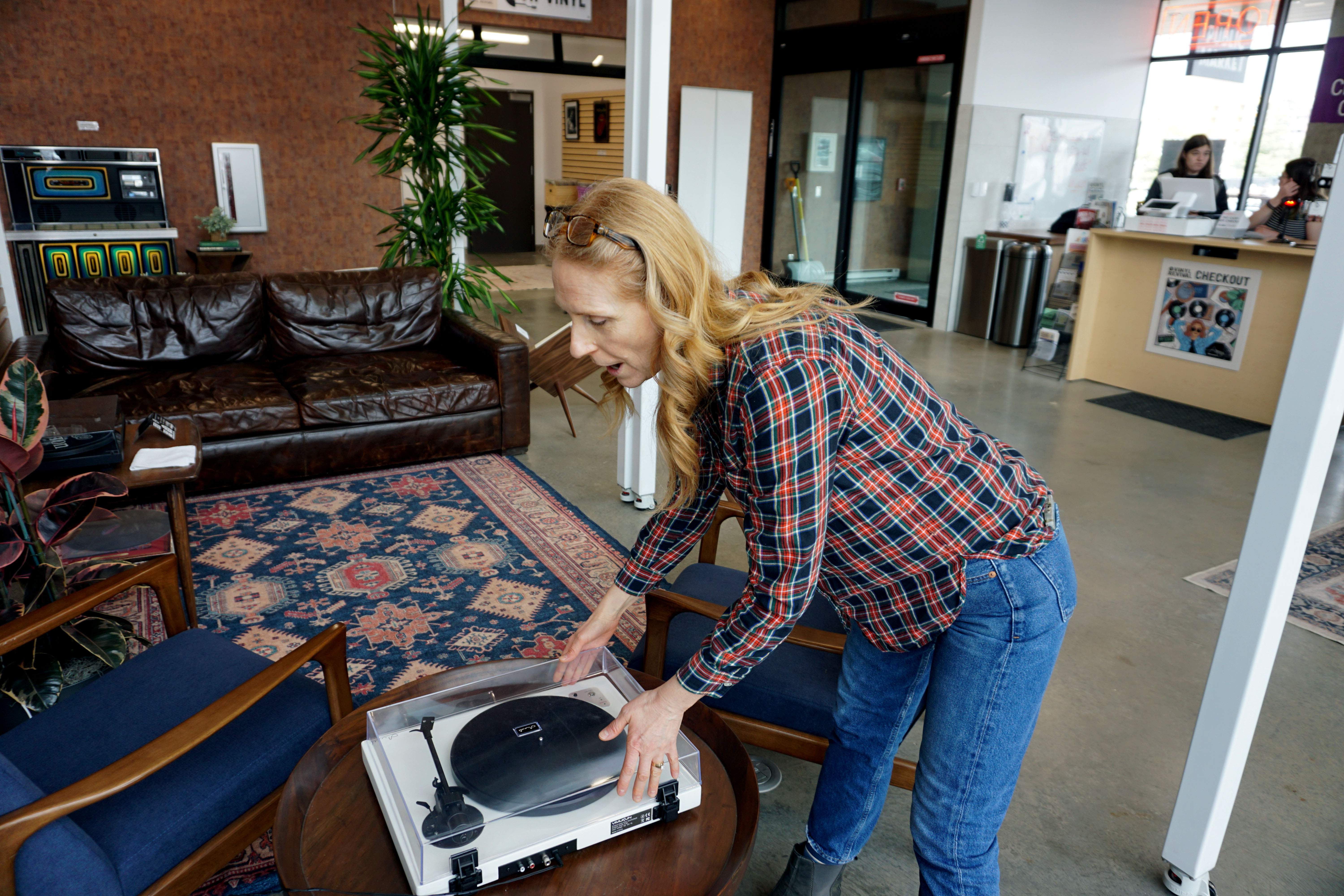 Millcreek Commons business development manager Lacy Gill demonstrates the listening section for vinyl collectors and buyers at a Vinyl Pop-Up event on Tuesday. The event features feature spin-offs, special item releases and DJ performances and runs through April 5.