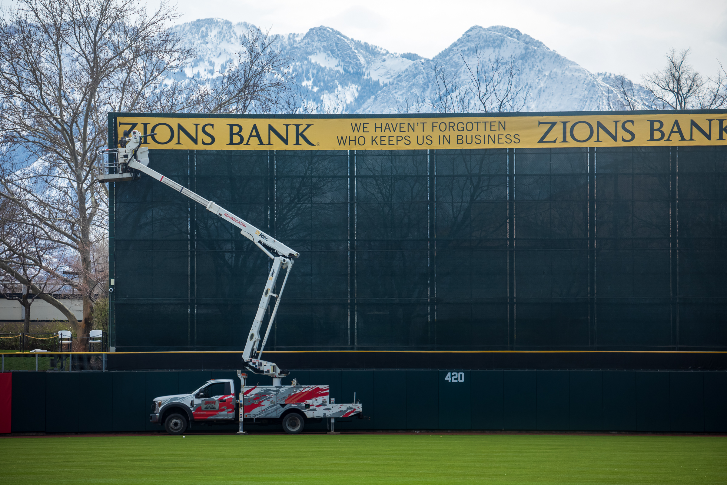 Crews repair signage on the Smith's Ballpark batter's eye on Wednesday. The team's home opener is slated for Tuesday against Tacoma.