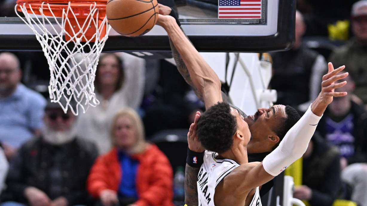 Utah Jazz forward John Collins (20) is blocked and fouled by San Antonio Spurs center Victor Wembanyama (1) as the Utah Jazz and the San Antonio Spurs play at the Delta Center in Salt Lake City on Wednesday, March 27, 2024.