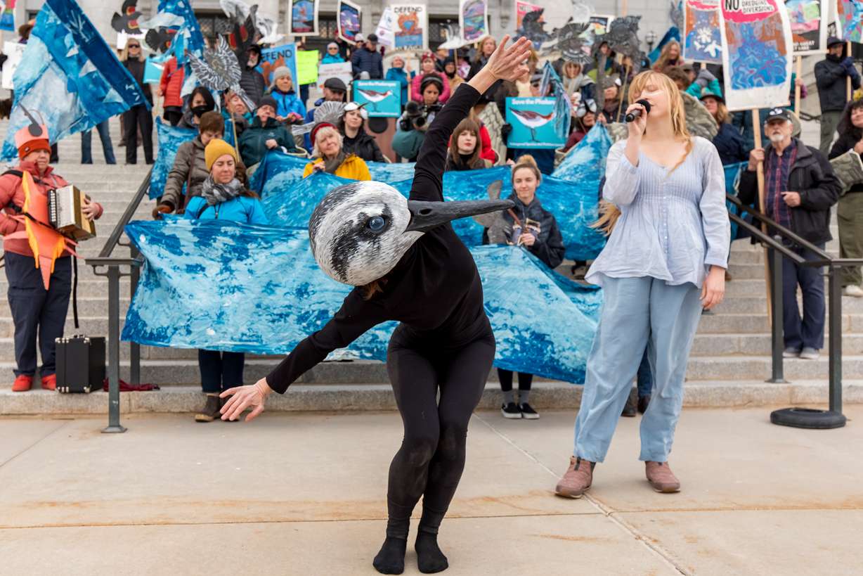 Bryn Watkins, left, performs a dance while wearing a Wilson's phalarope mascot head while Sarah Woodbury, right, sings at a rally celebrating new efforts to protect the species at the Utah Capitol on Thursday.