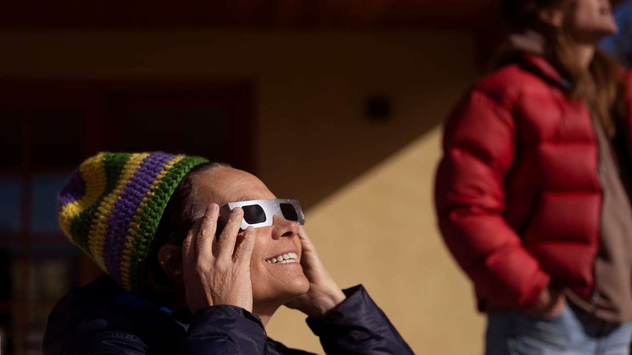 Jill Baillie and Courtney Henley watch an annular solar eclipse in Torrey on Oct. 14. The April 8 solar eclipse is expected to lure some 4 million people to the dozen-plus U.S. states in the path of totality for the celestial event.