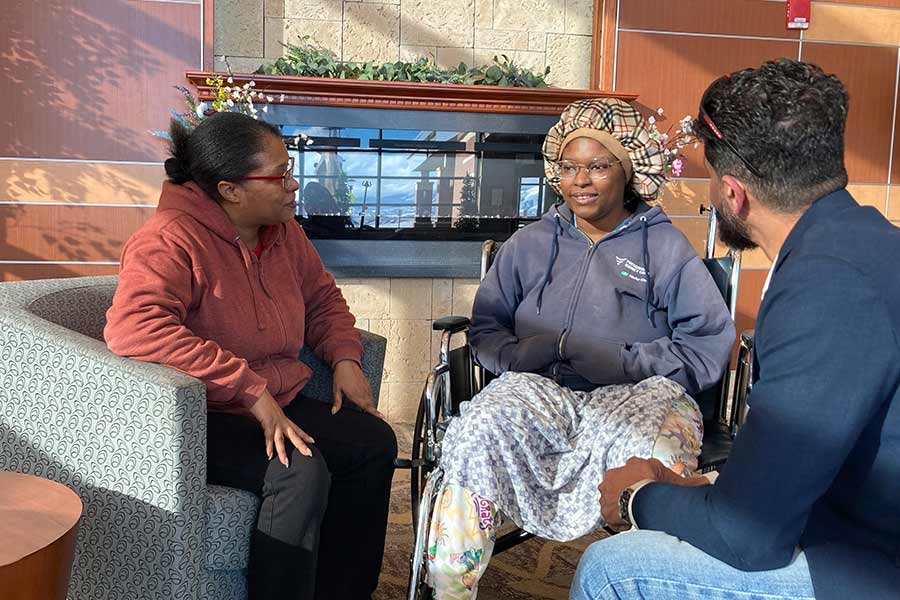 Britnay Campbell-Martin, center, sits with her mother, Vicki Martin, left, and Dr. Fahim Rahim, in an undated photo. Campbell-Martin had been stuck in a hospital for months while her children awaited her arrival at their out-of-state home.