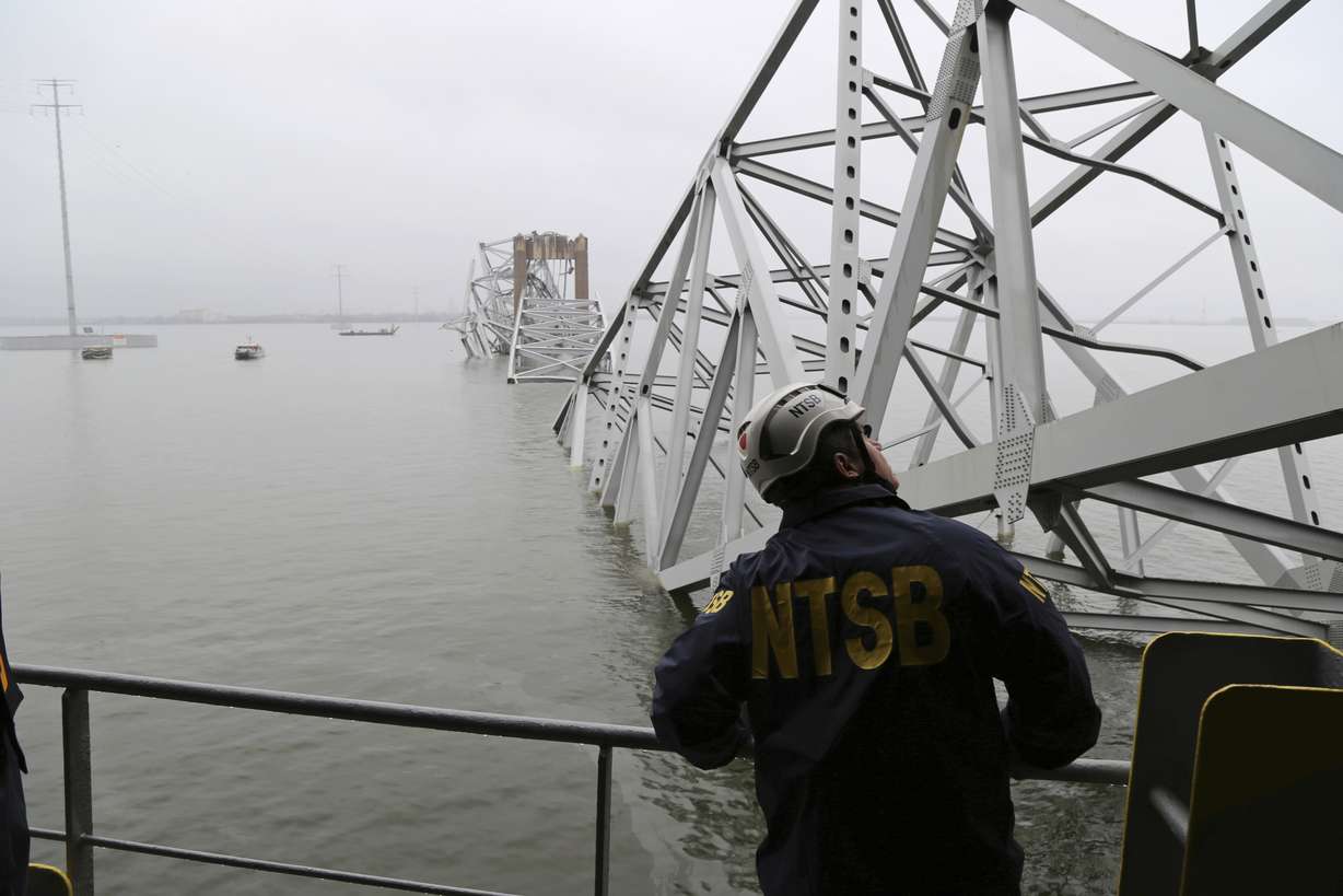 In this image released by the National Transportation and Safety Board, a NTSB investigator is seen on the cargo vessel Dali, which struck and collapsed the Francis Scott Key Bridge, Wednesday, in Baltimore, Md.