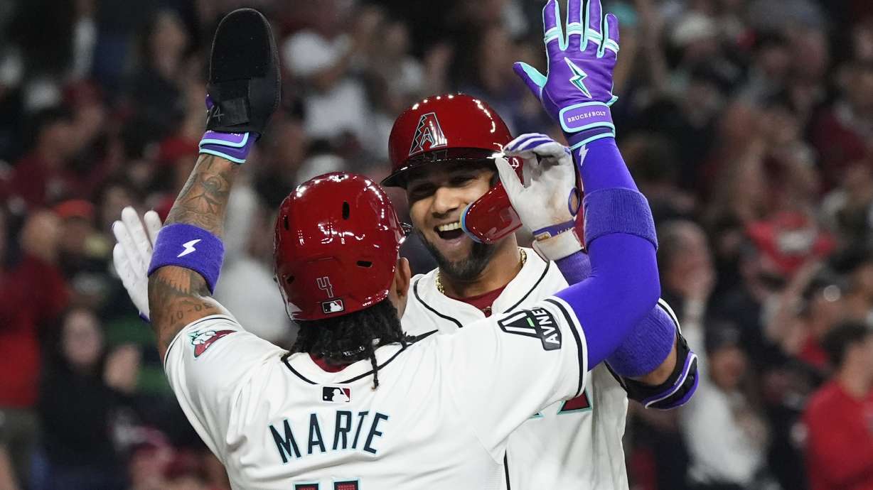 Arizona Diamondbacks' Lourdes Gurriel Jr., rear, celebrates his two-run home run against the Colorado Rockies with Ketel Marte during the first inning of a baseball game Thursday, March 28, 2024, in Phoenix.