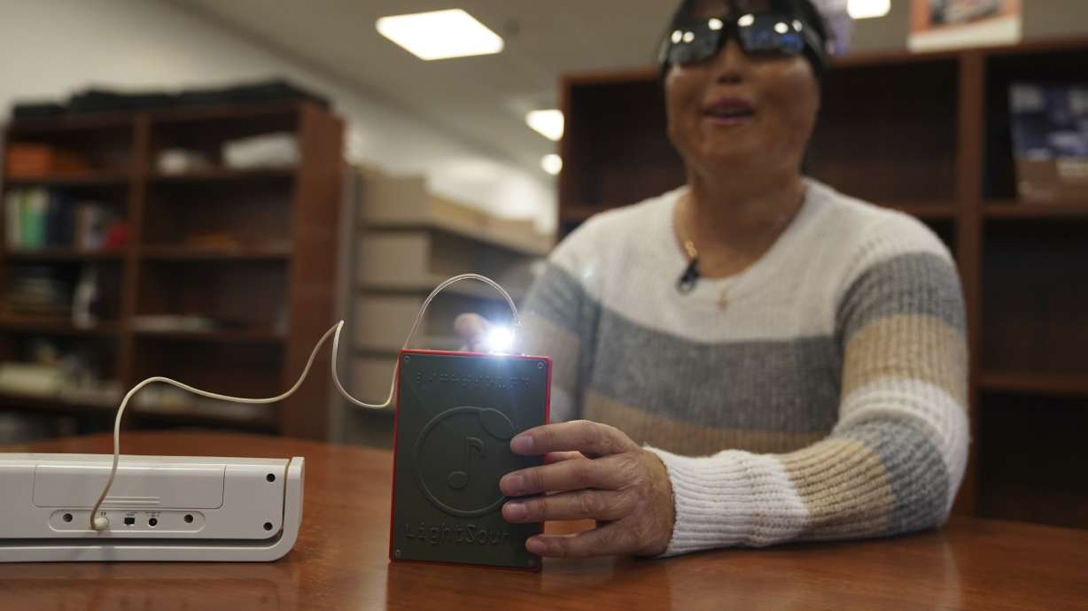 Minh Ha, with the Perkins School for the Blind, tries a LightSound device in Watertown, Mass., on March 2. The technology will allow people who are blind or visually impaired to hear and feel April's total solar eclipse.