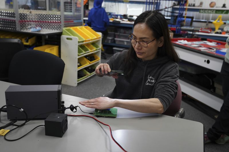Katherine Tso tests components of a LightSound device at the New England Sci-Tech education center in Natick, Mass., on March 2. When the sun is bright, the device plays high flute notes. As the moon begins to cover the sun, the mid-range notes are those of a clarinet. Darkness is rendered by a low clicking sound.