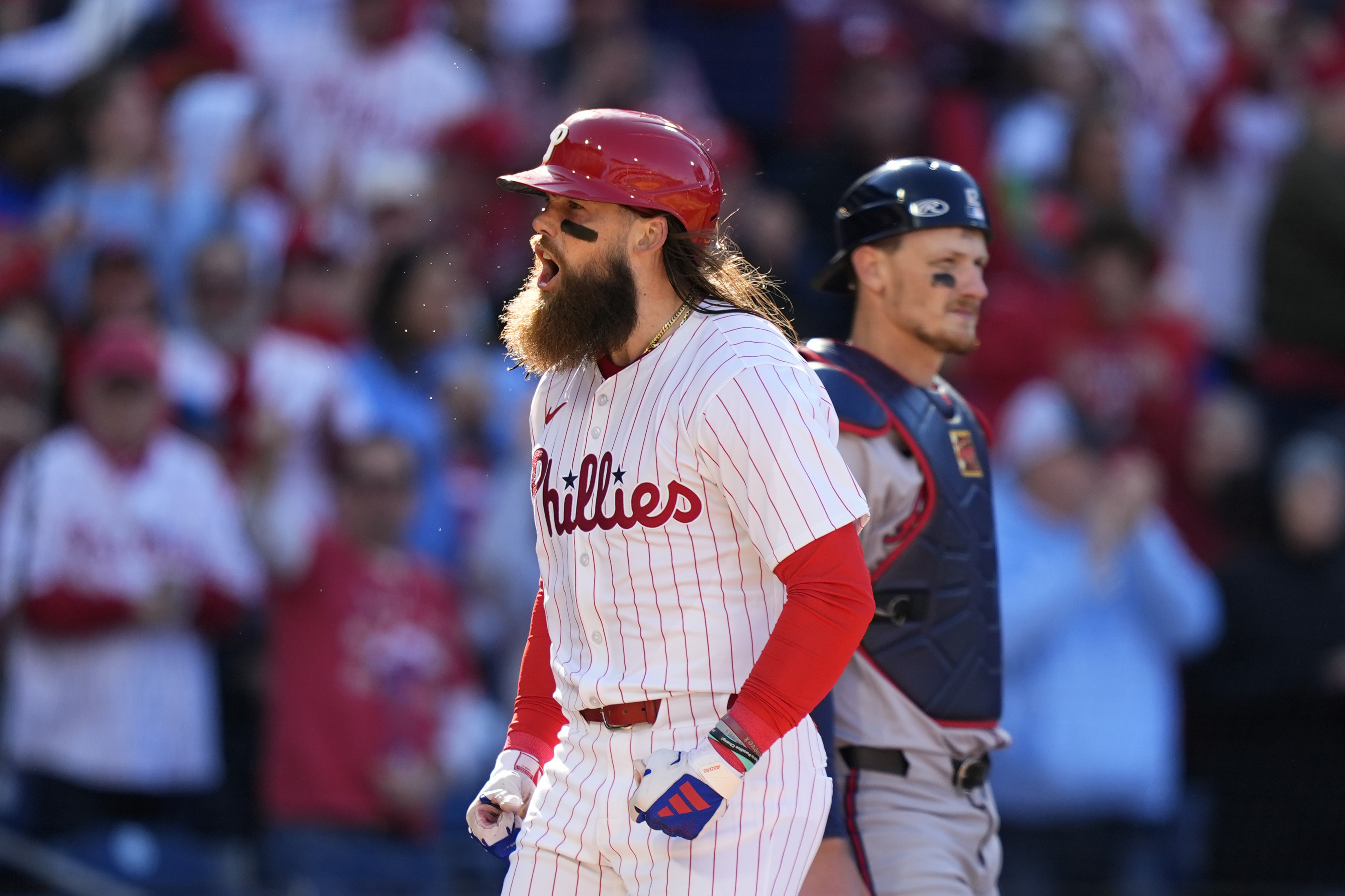 Philadelphia Phillies' Brandon Marsh, left, reacts past Atlanta Braves catcher Sean Murphy after hitting a two-run home run against pitcher Spencer Strider during the fifth inning of an opening-day baseball game, Friday, March 29, 2024, in Philadelphia. 