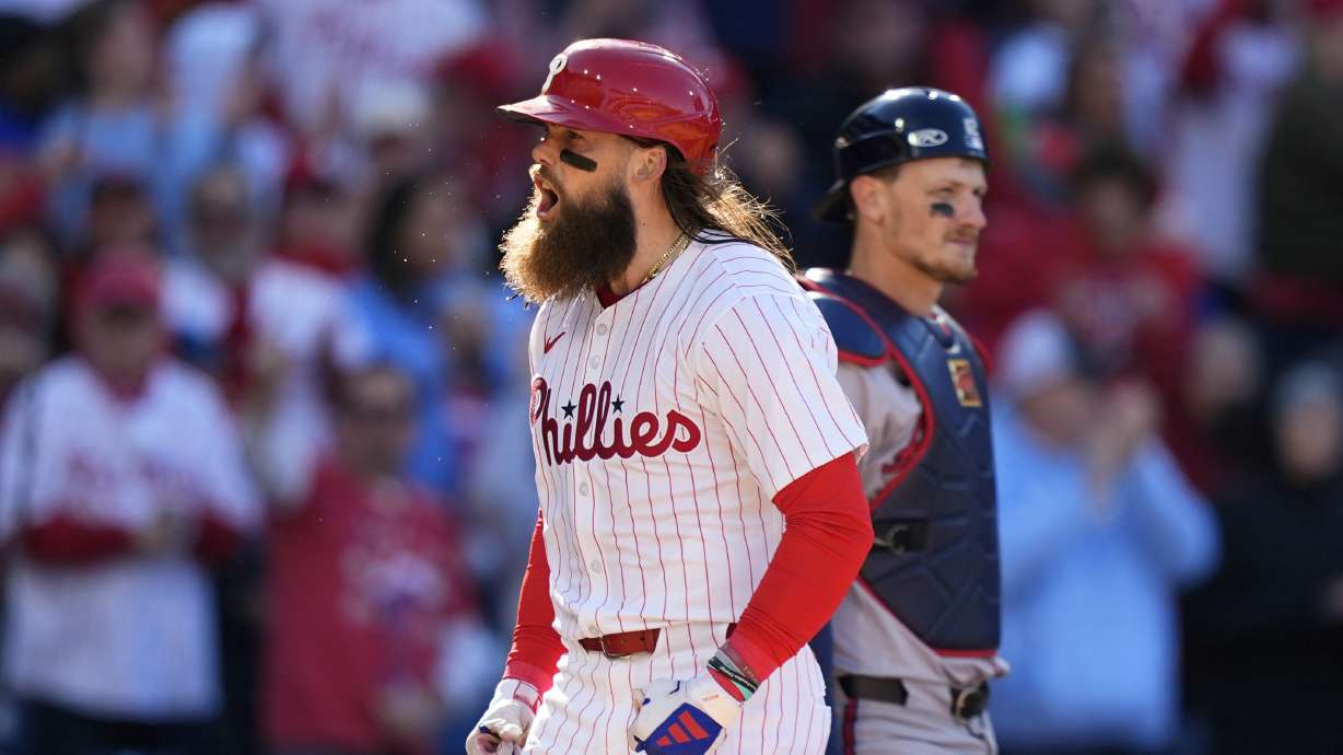 Philadelphia Phillies' Brandon Marsh, left, reacts past Atlanta Braves catcher Sean Murphy after hitting a two-run home run against pitcher Spencer Strider during the fifth inning of an opening-day baseball game, Friday, March 29, 2024, in Philadelphia.