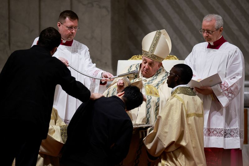 Pope Francis baptises a man during the Easter Vigil in Saint Peter's Basilica at the Vatican, Saturday. The Pope soldiered through a more than 2-hour Easter Vigil Mass in St Peter's Basilica amid renewed concerns about the 87-year-old's frail condition.