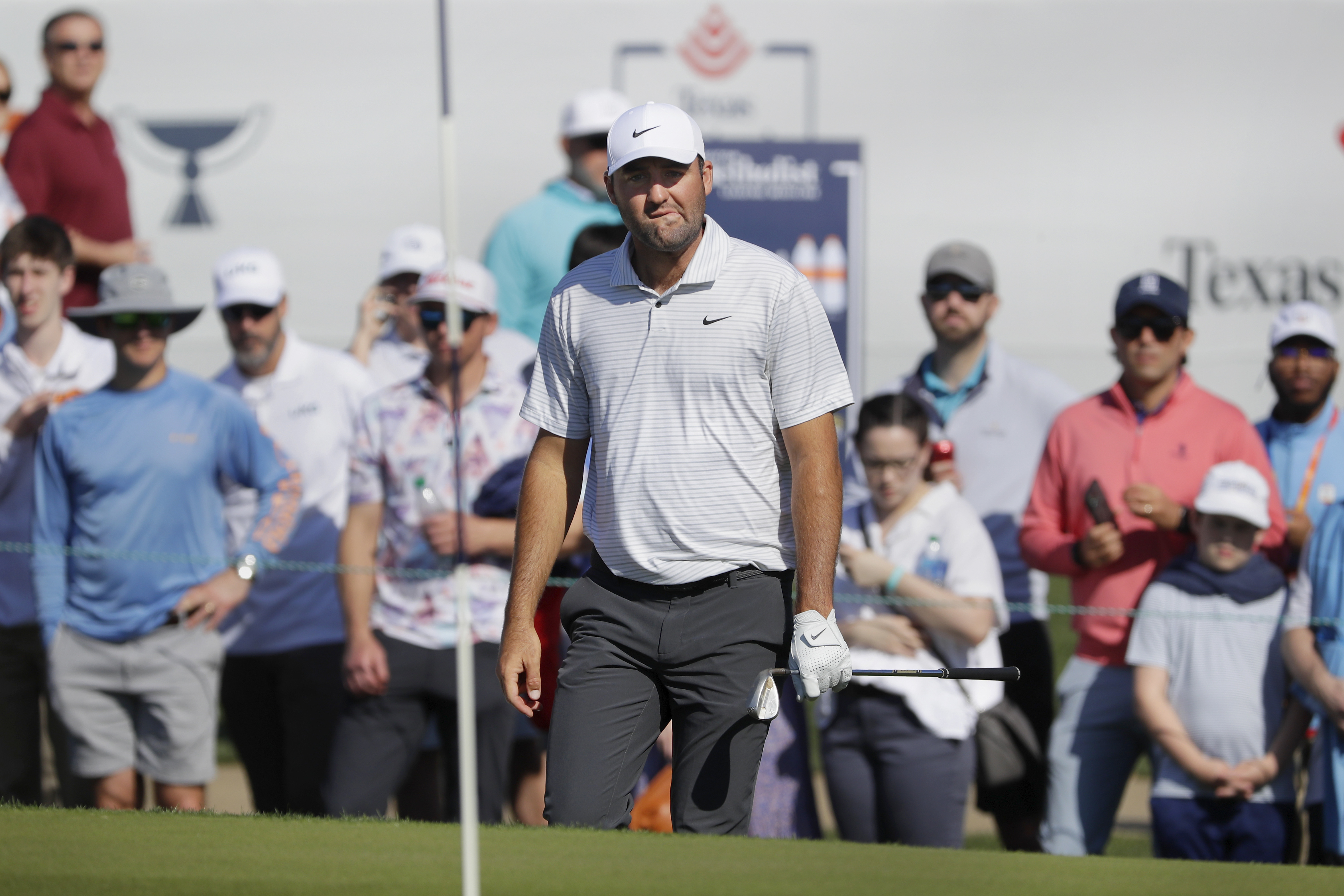 Scottie Scheffler looks at the pin before hitting out of the bunker on the 18th green during the first round of the Houston Open golf tournament Thursday, March, 28, 2024, in Houston. 
