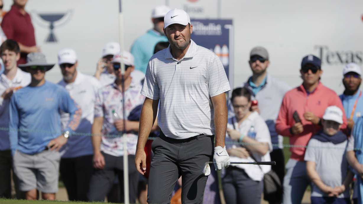 Scottie Scheffler looks at the pin before hitting out of the bunker on the 18th green during the first round of the Houston Open golf tournament Thursday, March, 28, 2024, in Houston.