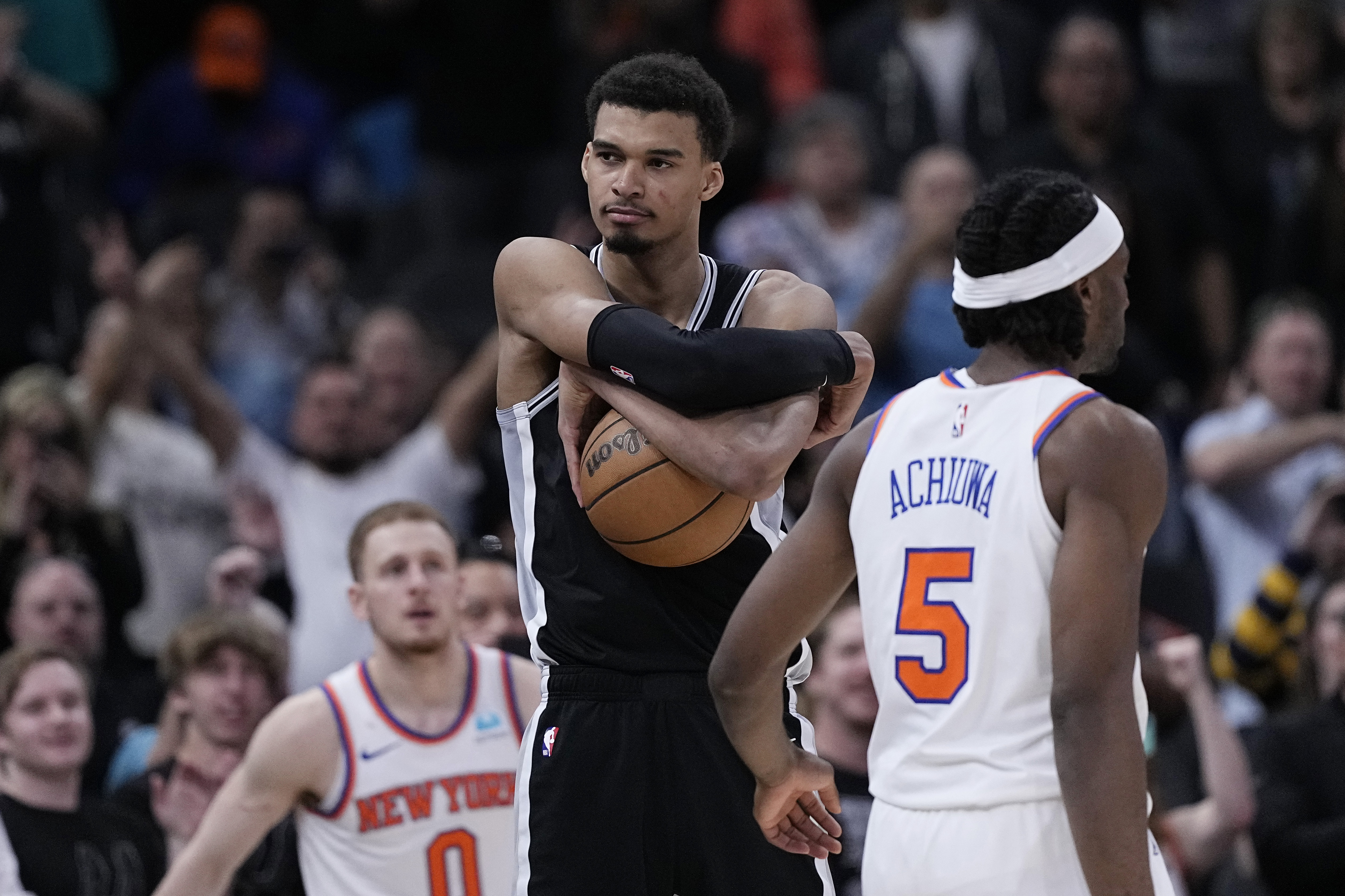 San Antonio Spurs center Victor Wembanyama, center, clutches the ball as they defeat the New York Knicks in an overtime in an NBA basketball game in San Antonio, Friday, March 29, 2024.