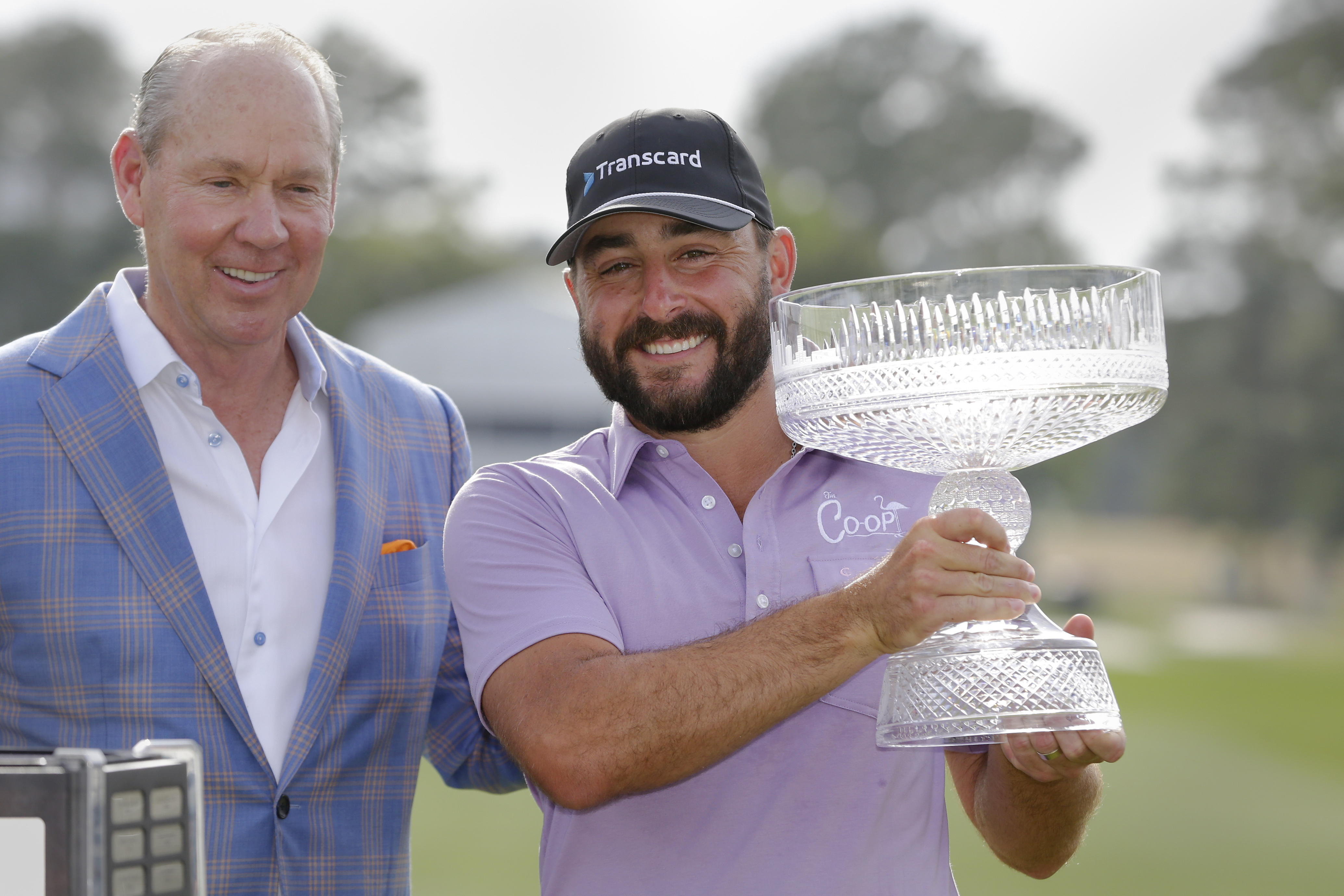 Jim Crane, left, owner of the Houston Astros baseball team, and Stephan Jaeger pose for photos with the trophy during ceremonies after Jaeger's win after the final round of the Houston Open golf tournament Sunday, March 31, 2024, in Houston. 