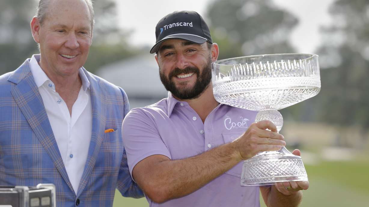 Jim Crane, left, owner of the Houston Astros baseball team, and Stephan Jaeger pose for photos with the trophy during ceremonies after Jaeger's win after the final round of the Houston Open golf tournament Sunday, March 31, 2024, in Houston.