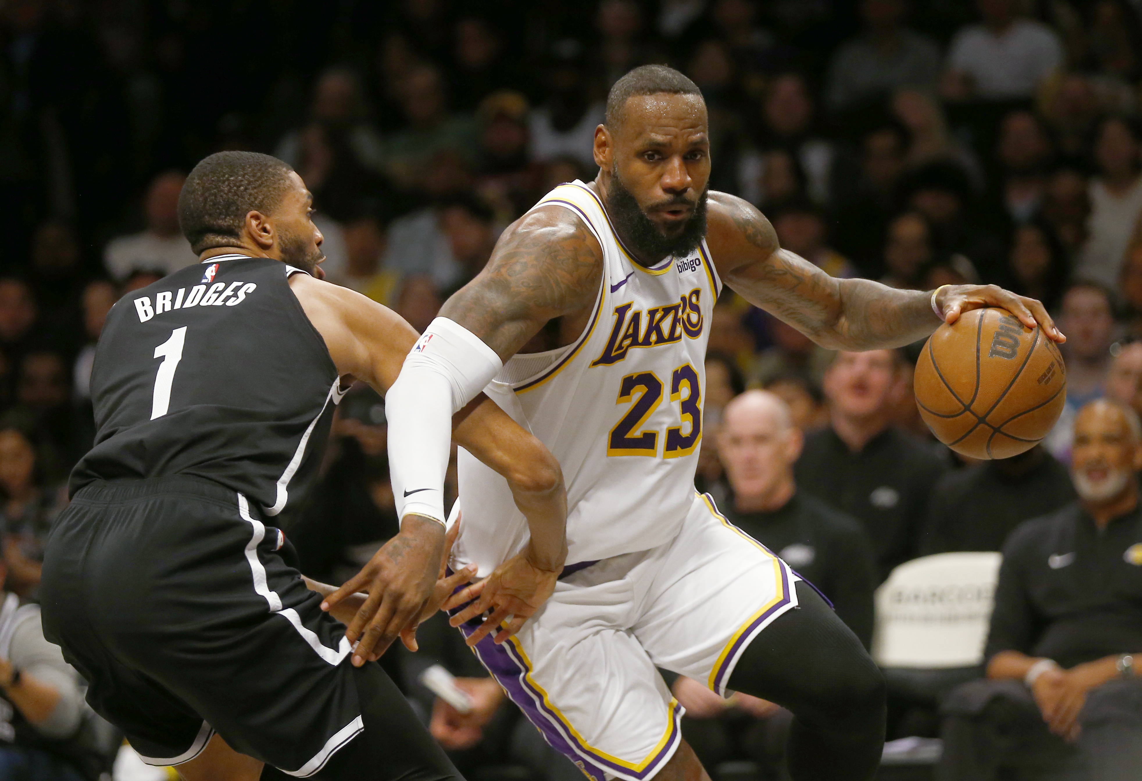 Los Angeles Lakers forward LeBron James (23) drives around Brooklyn Nets guard Mikal Bridges (1) during the first half of an NBA basketball game Sunday, March 31, 2024, in New York. 