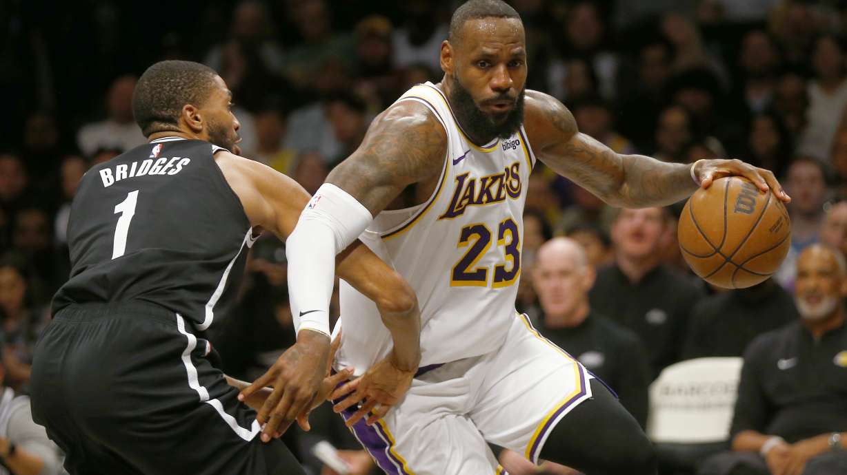 Los Angeles Lakers forward LeBron James (23) drives around Brooklyn Nets guard Mikal Bridges (1) during the first half of an NBA basketball game Sunday, March 31, 2024, in New York.