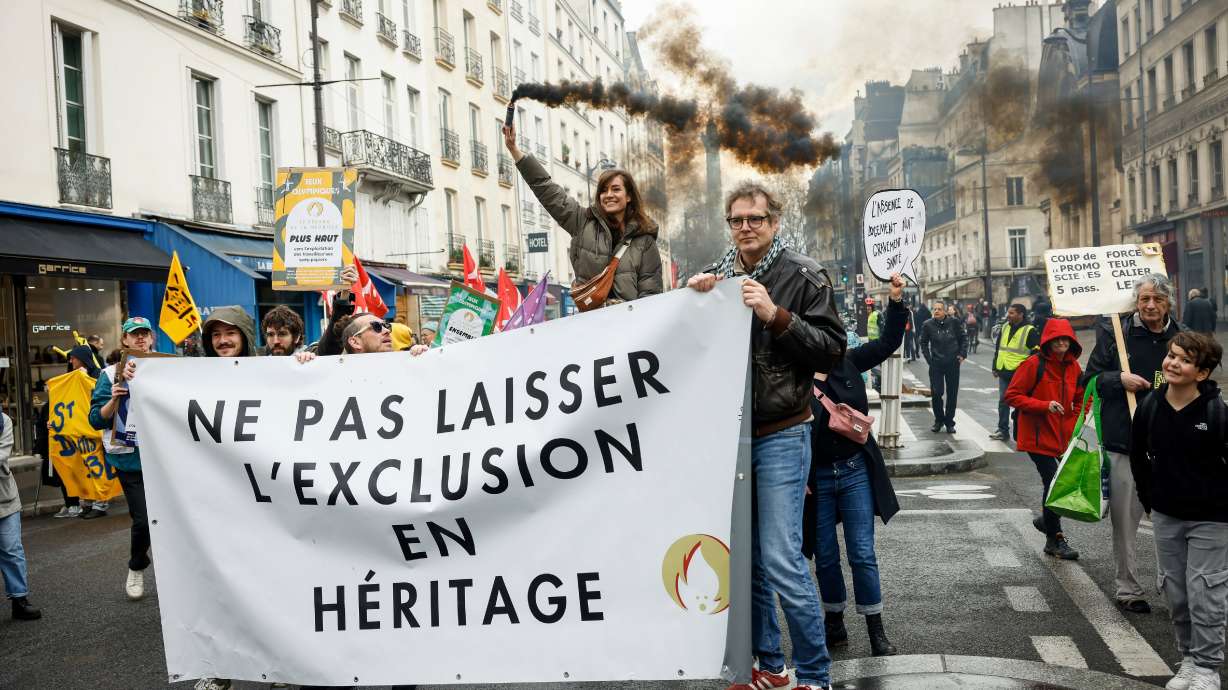 Members of Le Revers de la Medaille group holds a banner that reads: "Do Not Leave Exclusion as a Legacy," during a protest to raise awareness about the social impact of the Paris 2024 Olympic Games, Monday, in Paris.