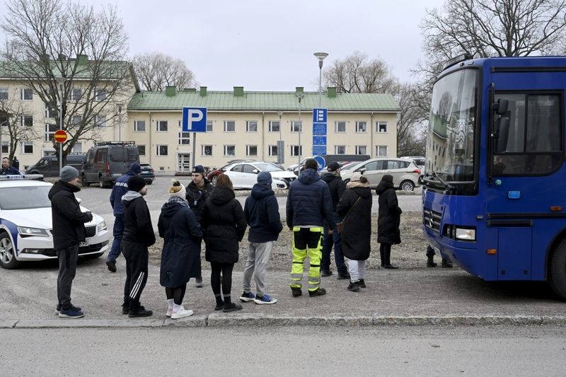 Police officers talk to family members of pupils at a school in Vantaa, Finland, on Tuesday. Three minors were injured in a school shooting on Tuesday. A suspect, also a minor, has been apprehended. 