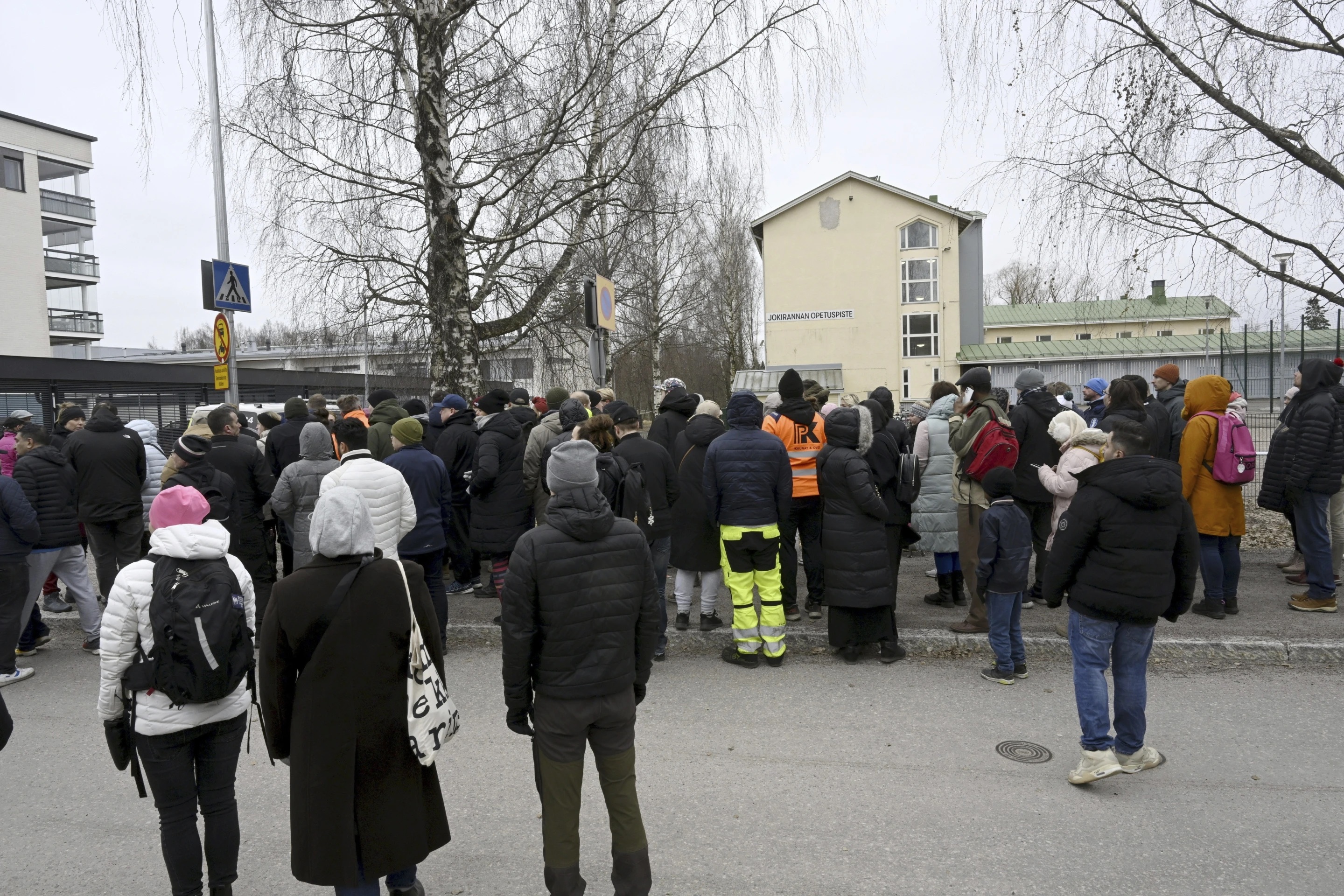 Family members of students at Viertola comprehensive school wait to enter the building in Vantaa, Finland, on Tuesday.