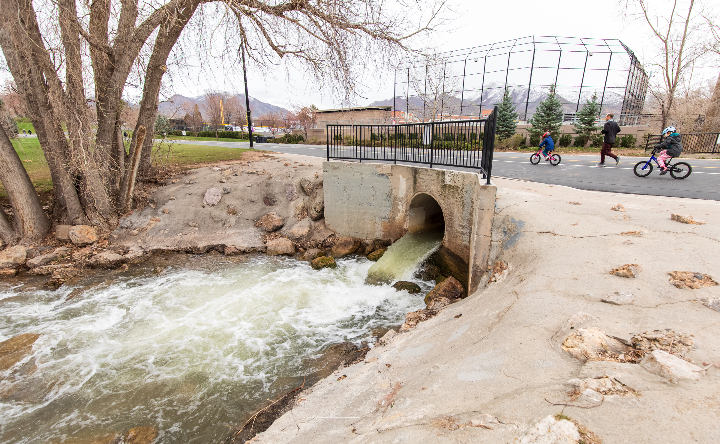 People travel over a culvert as Parleys Creek flows through it. Salt Lake City Public Utilities already started controlled releases from reservoirs in Parleys canyons, but increased daily releases on Tuesday.