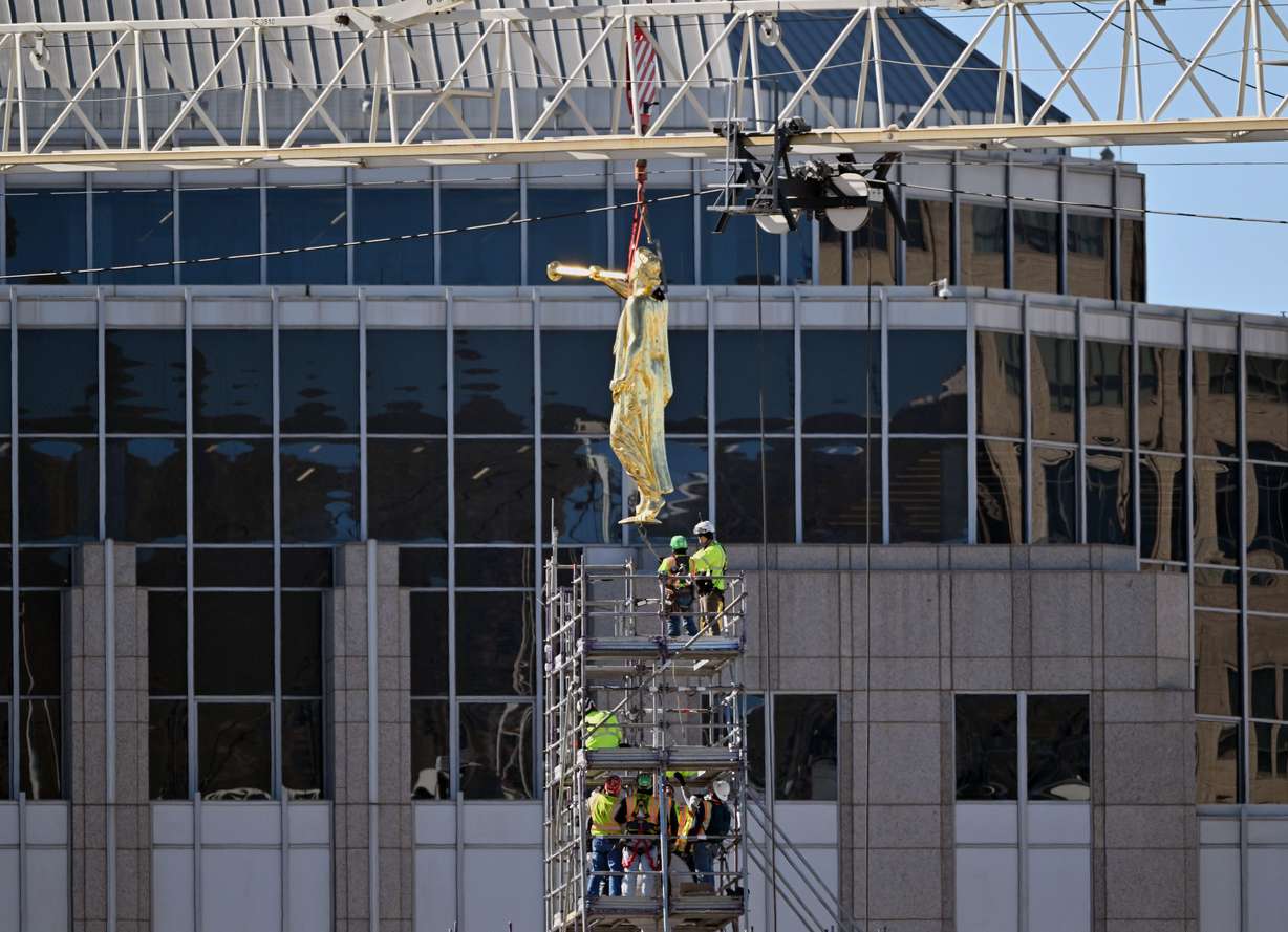 The Angel Moroni statue is lifted and placed atop the Salt Lake Temple in Salt Lake City on Tuesday, April 2, 2024.