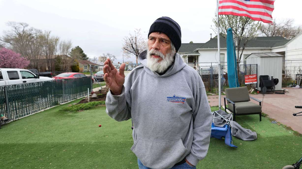 Troy Vialpando talks about his artificial grass at his home in Salt Lake City on Monday. Salt Lake City has asked him to remove the grass since it doesn’t meet code.