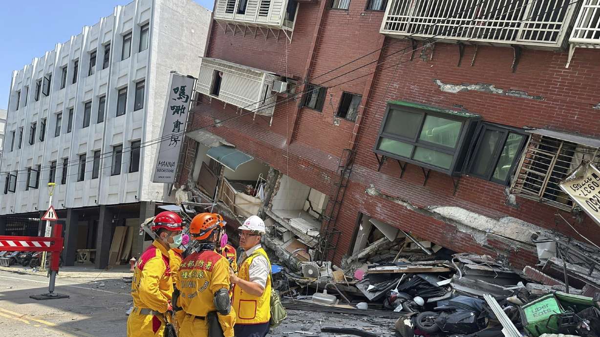 Members of a search and rescue team prepare outside a leaning building in the aftermath of an earthquake in Hualien, eastern Taiwan on Wednesday. Taiwan's strongest earthquake in a quarter century rocked the island during the morning rush Wednesday, damaging buildings and creating a tsunami that washed ashore on southern Japanese islands.