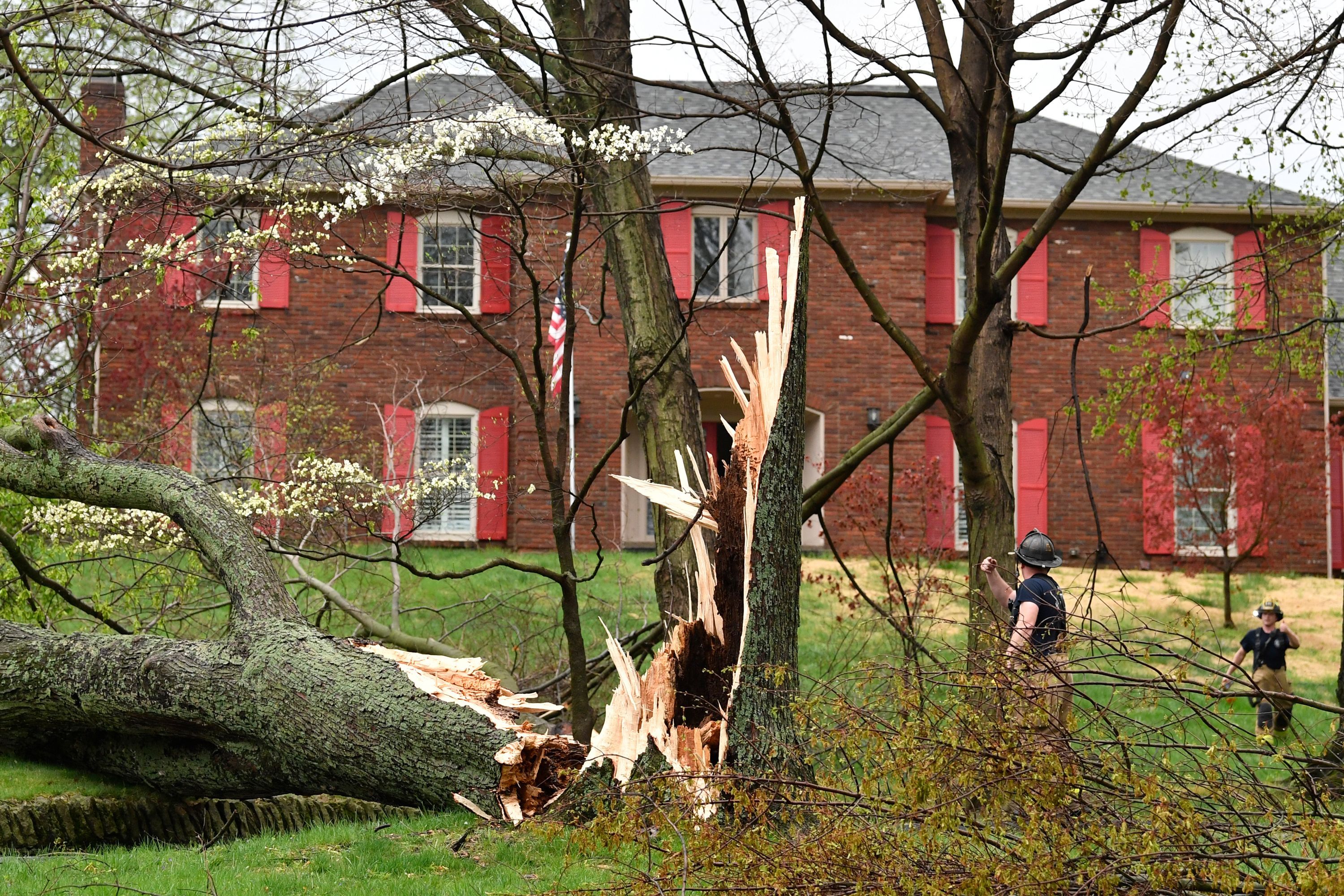 Firefighters with the Anchorage Middletown Fire Department check houses for gas leaks following severe storms that passed through Prospect, Ky., Tuesday.