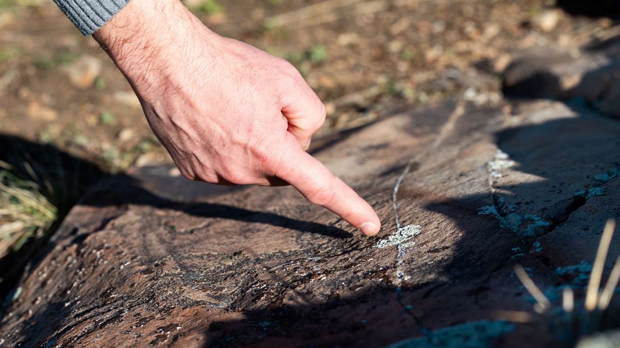 Paul Jerome, Eagle Mountain city manager, points out some petroglyphs on April 3, 2024. A proposed bill seeks to expand the punishment for damage to natural features or archaeological sites, while creating a fund to repair them.