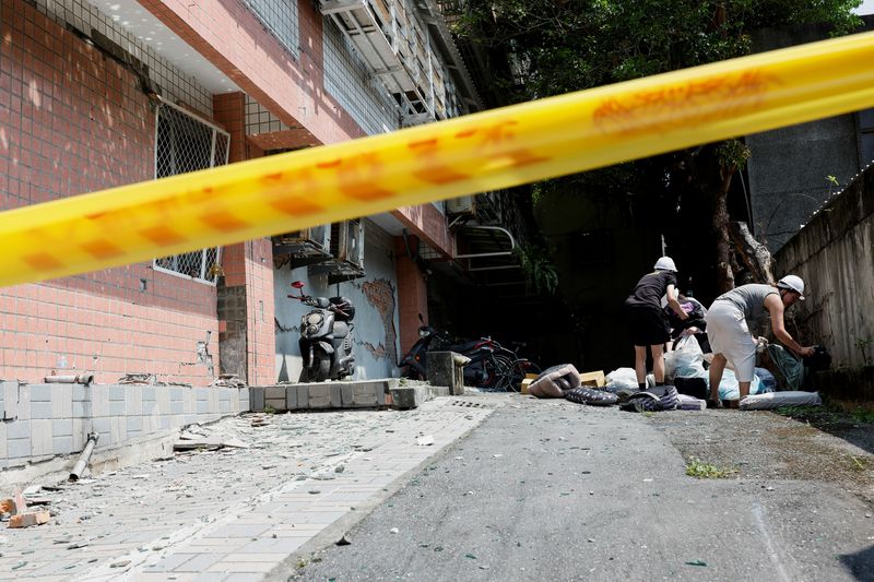 Residents collect their belongings outside a damaged building, following the earthquake, in Hualien, Taiwan, Thursday.