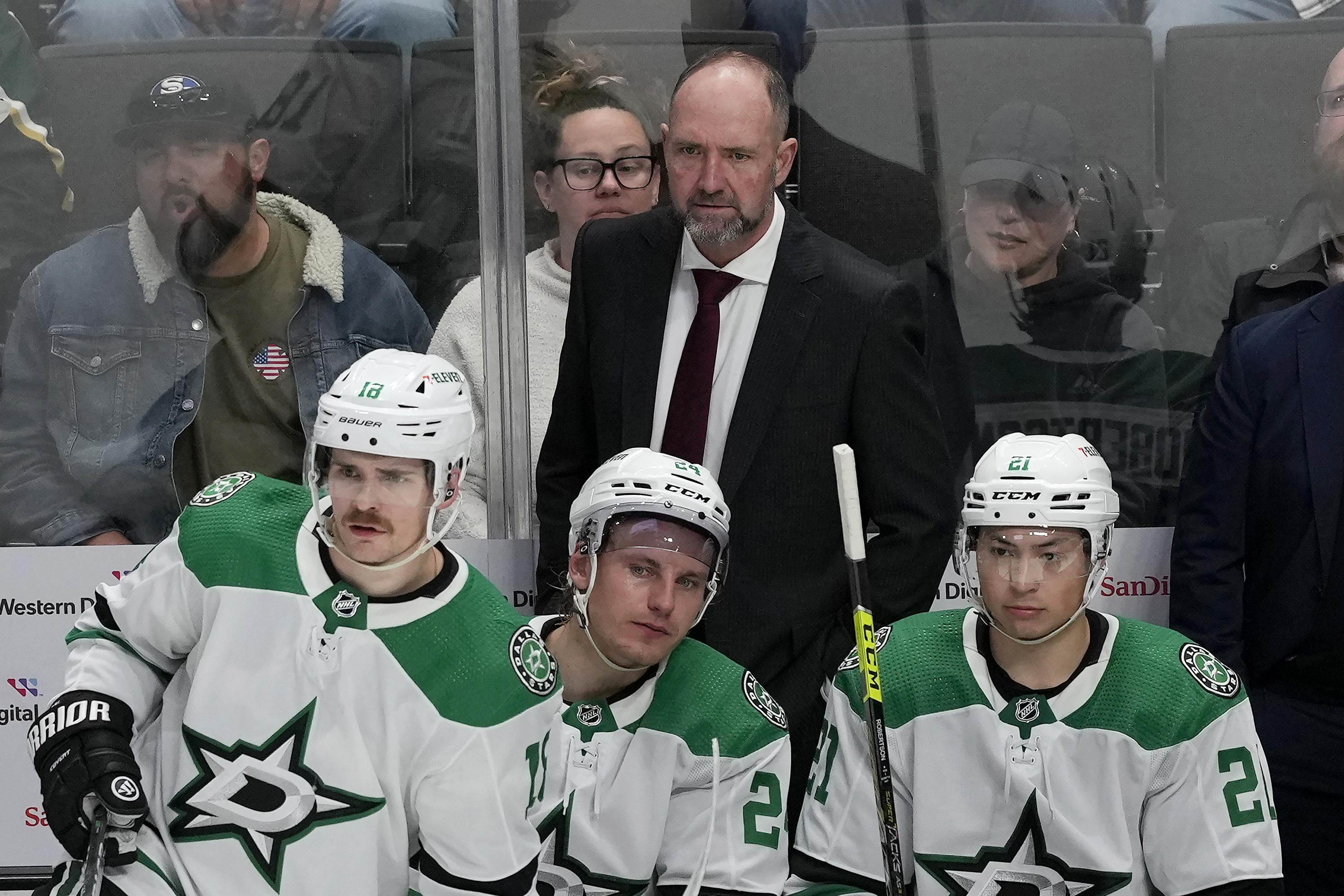 Dallas Stars coach Peter DeBoer stands behind center Sam Steel (18), center Roope Hintz (24) and left wing Jason Robertson (21) during the third period of the team's NHL hockey game against the San Jose Sharks in San Jose, Calif., Tuesday, March 26, 2024.