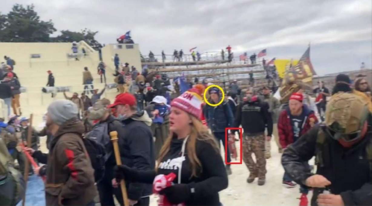 Image from court documents allegedly showing Zach Rash (circled in yellow) carrying a fire extinguisher among a group of rioters at the U.S. Capitol on Jan 6. 2021.