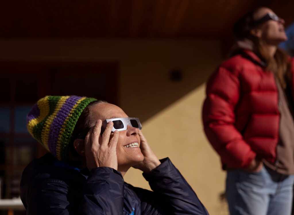 Jill Baillie and Courtney Henley watch an annular solar eclipse in Torrey, Wayne County, on Oct. 14, 2023, wearing eclipse glasses for eye protection.