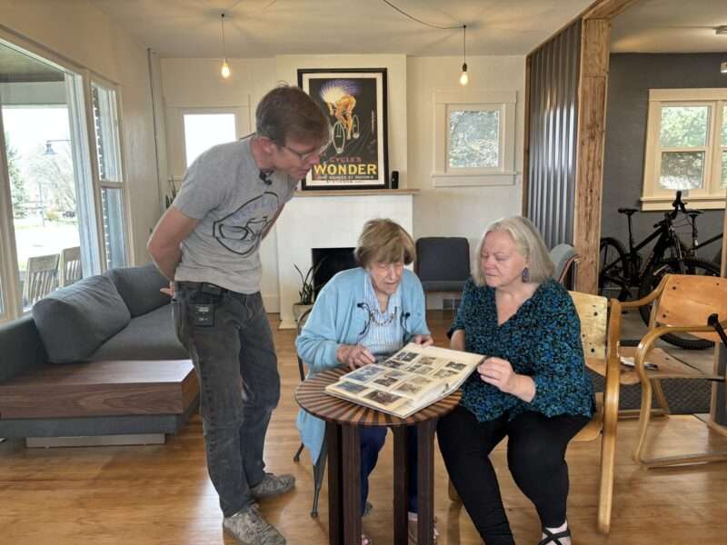 Steven Park, Dorothy Switzer and Becky McDonald look at old photos Thursday and tell stories after Park found a handwritten note from Switzer's brother in a Springville home.