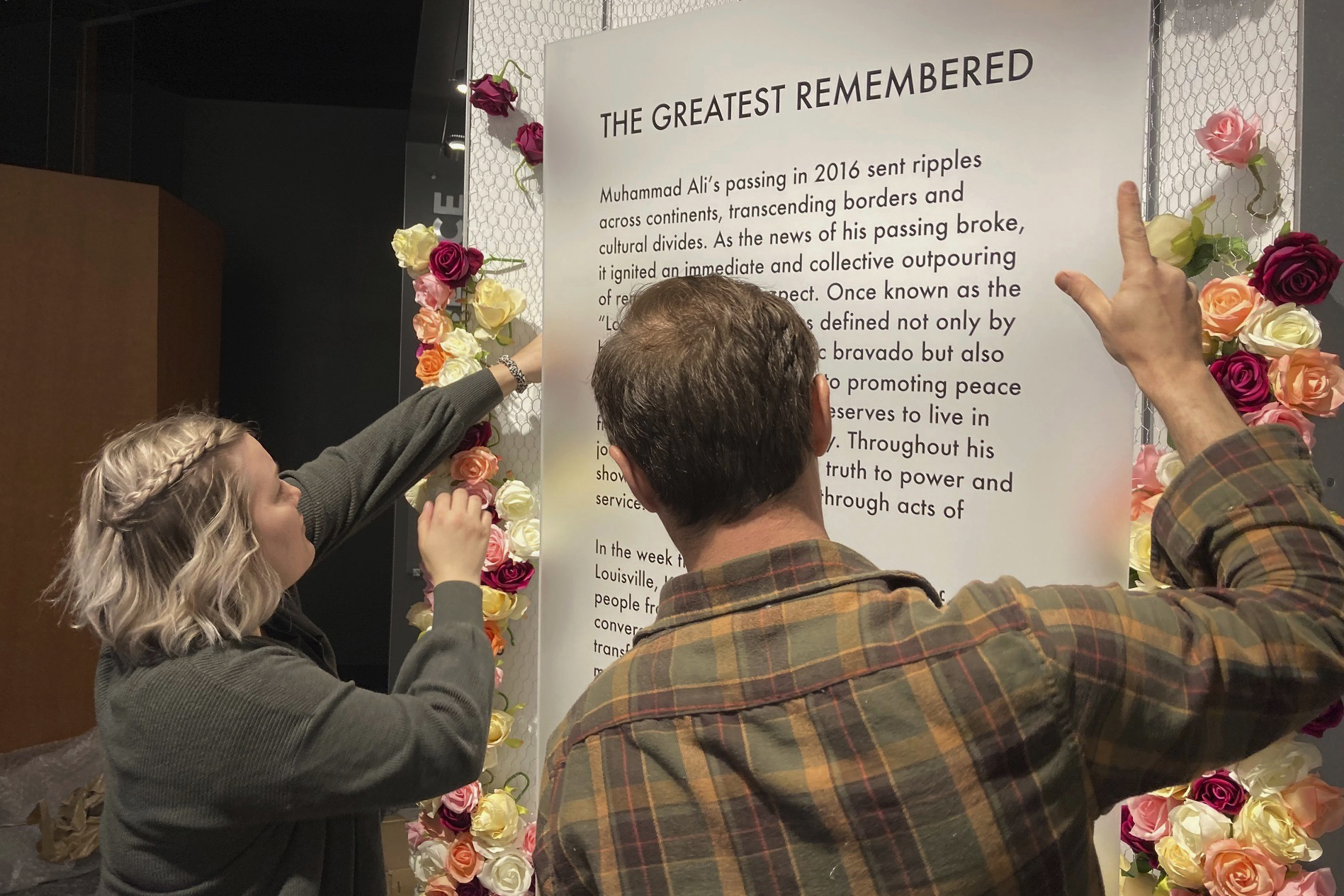 The story is scheduled to be released at 12:01 am ET Saturday. Here's a caption: Bess Goldy, left, helps arrange a display at the Muhammad Ali Center in Louisville, Ky., on Thursday, April 4, 2024. Goldy is curator of a new exhibit chronicling the outpouring of emotions in Ali's hometown following the boxing champion's death in 2016. 