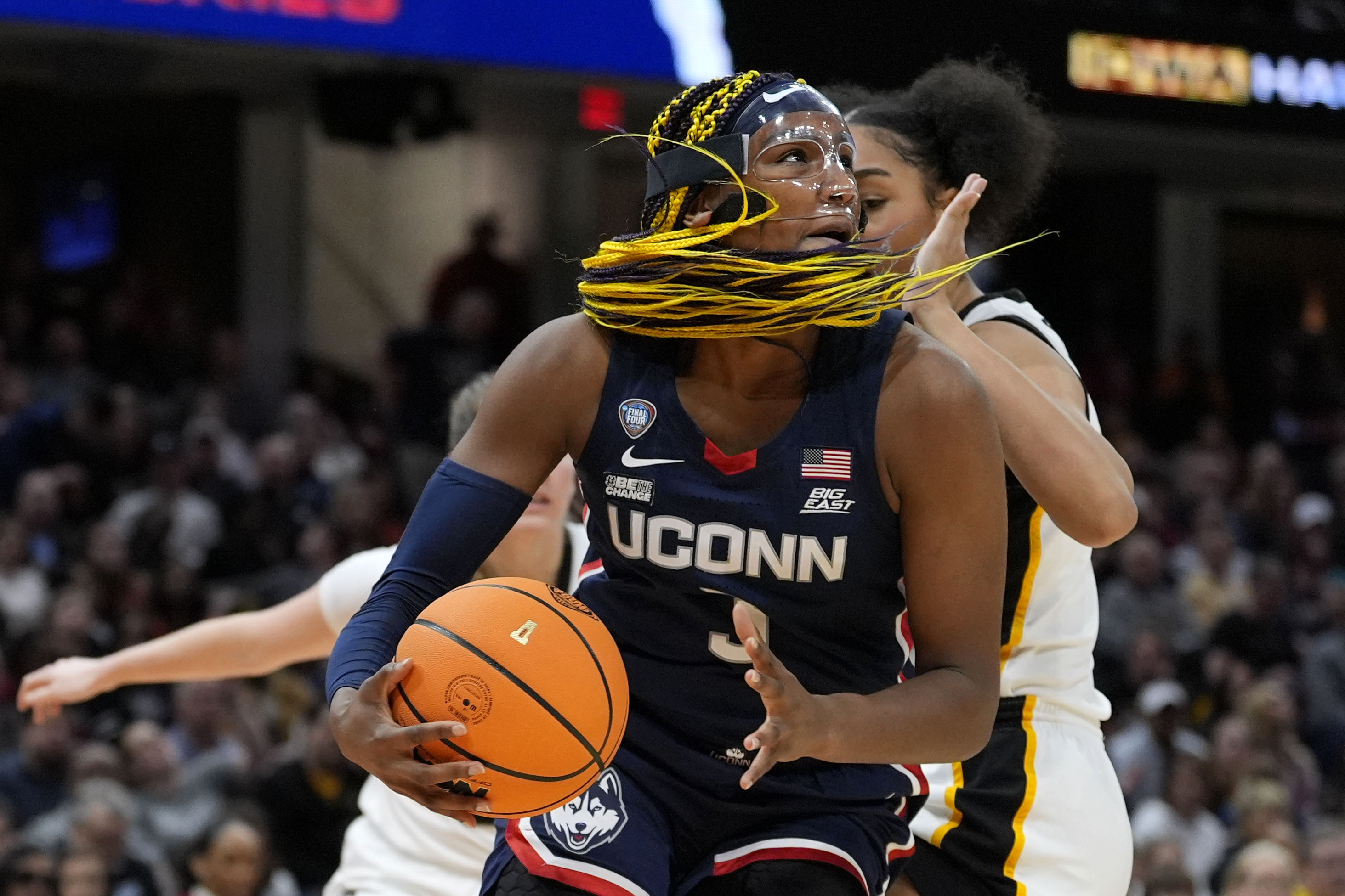 UConn forward Aaliyah Edwards drives to the basket in front of Iowa forward Hannah Stuelke, rear, during the first half of a Final Four college basketball game in the women's NCAA Tournament, Friday, April 5, 2024, in Cleveland. 