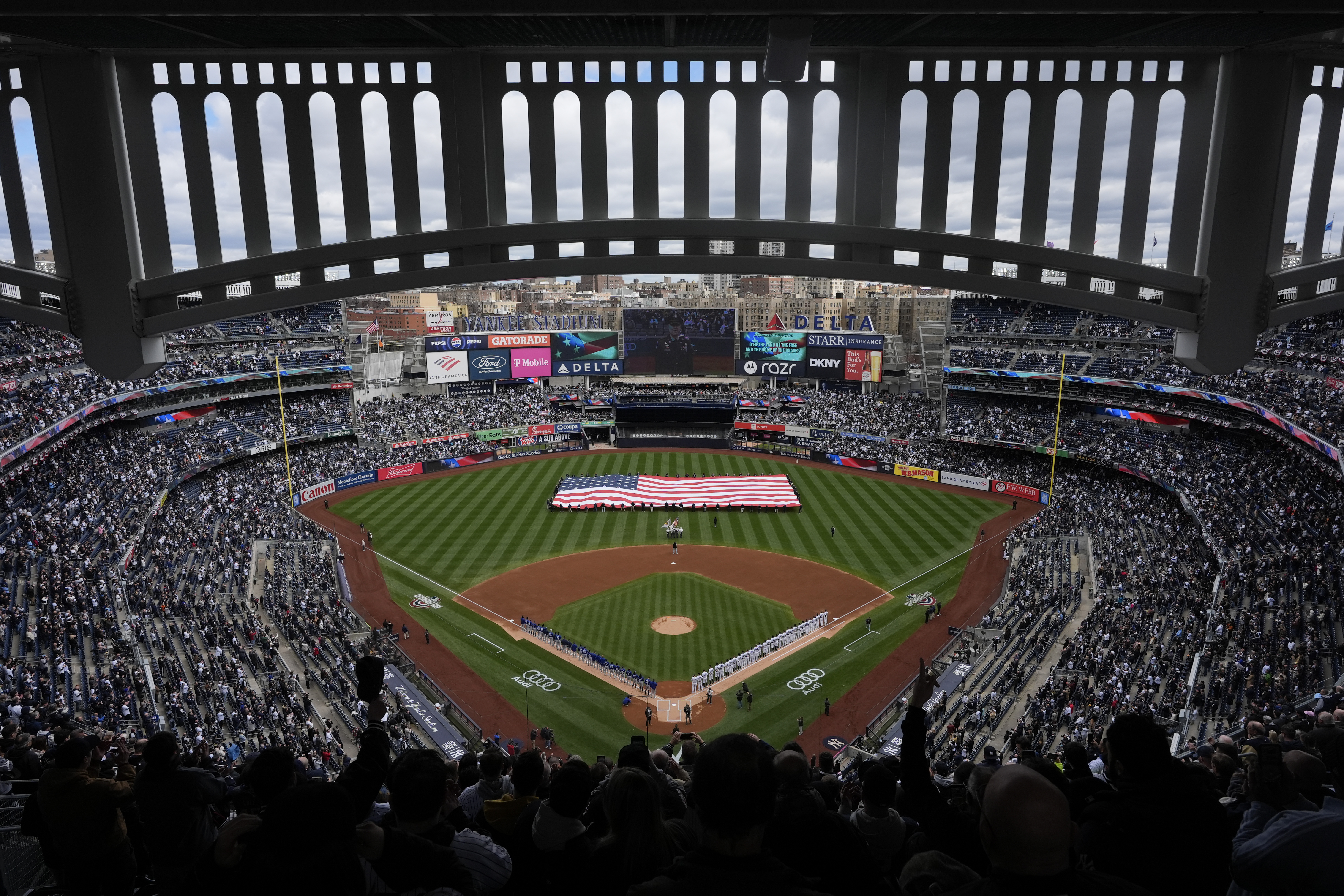 A giant American flag is unfurled before the start of the home-opener baseball game at Yankee Stadium between the New York Yankees and the Toronto Blue Jays, Friday, April 5, 2024, in New York. 